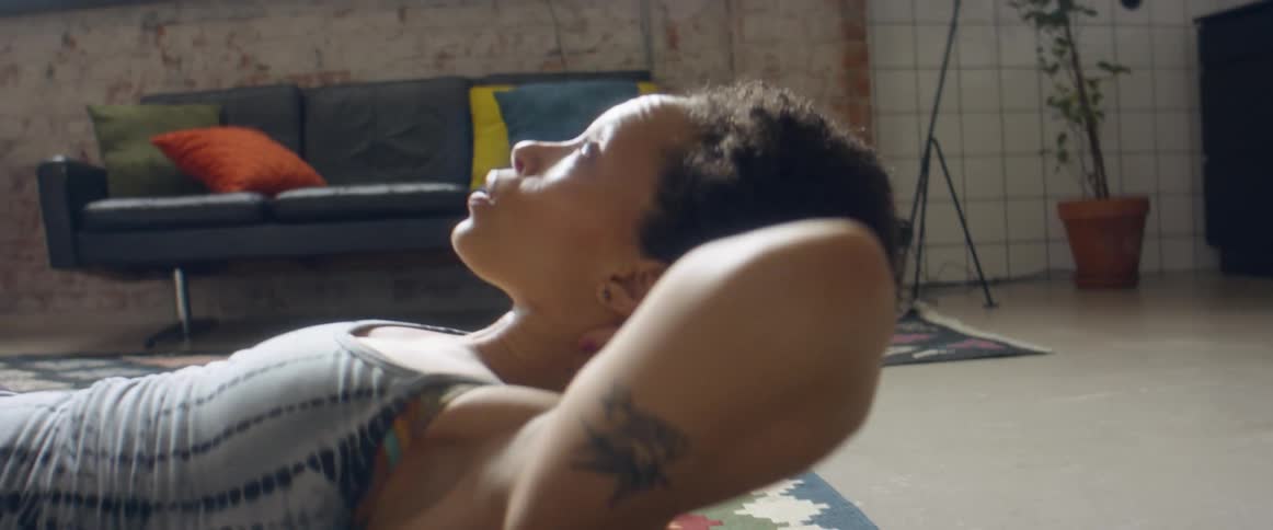 Woman does half crunches in the living room at home