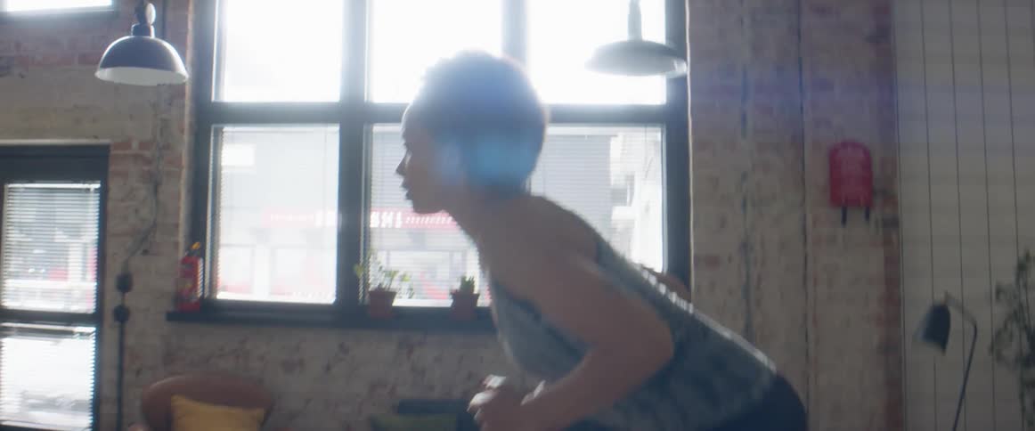 A woman sprints on the spot in her living room