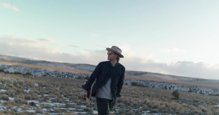 A man walking through a field in the winter