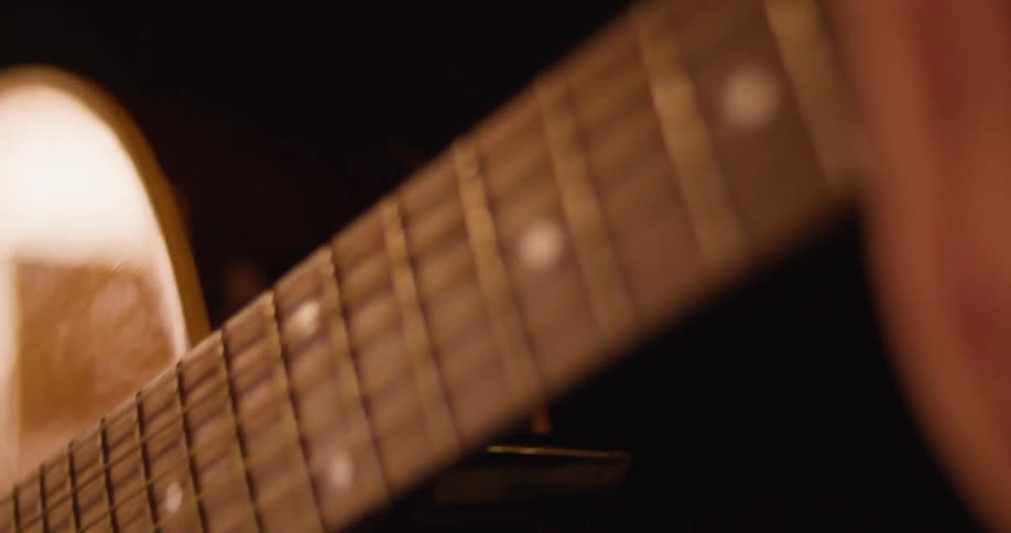 Close up of a person playing an acoustic guitar