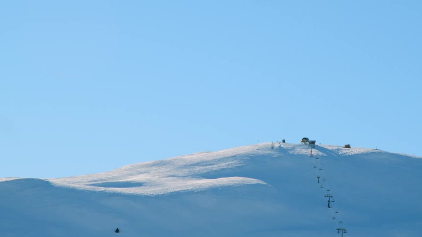A ski lift on a snow covered mountainside in winter