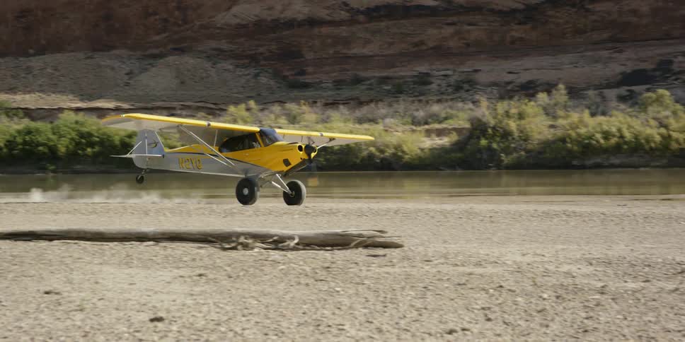 A plane slowly lands on a field