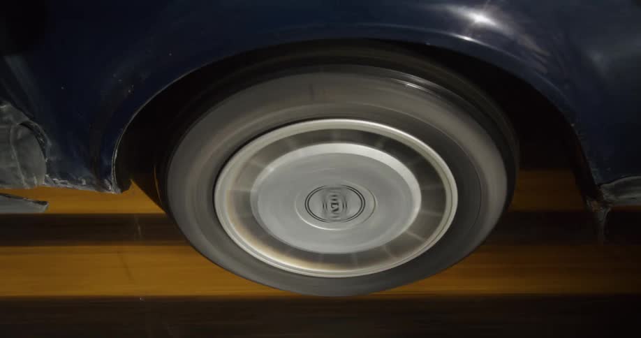 A car tire traveling over a paved road