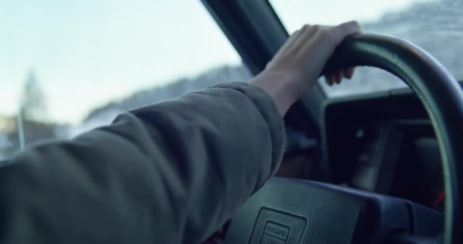 A person is driving a car in a rural area