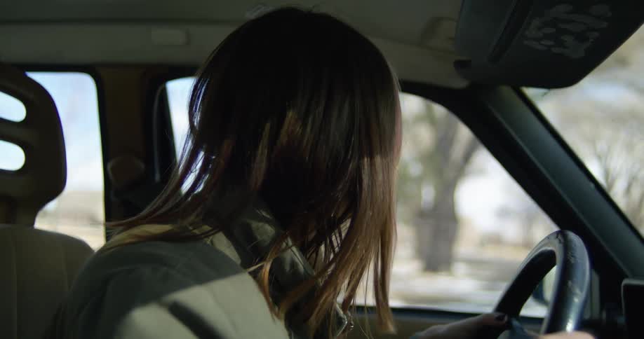 A female driver looking both ways before turning right onto a road