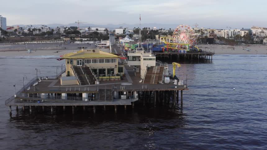 An aerial view of a pier with a ferris wheel in a coastal town