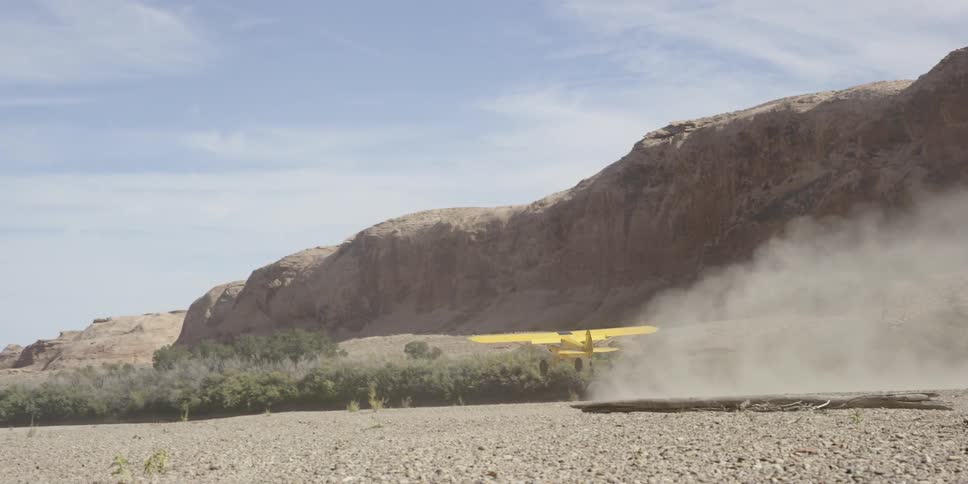 A yellow plane slowly takes off