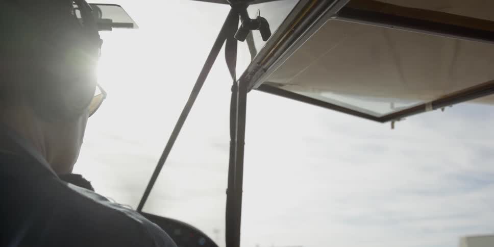A man sits driving a plane
