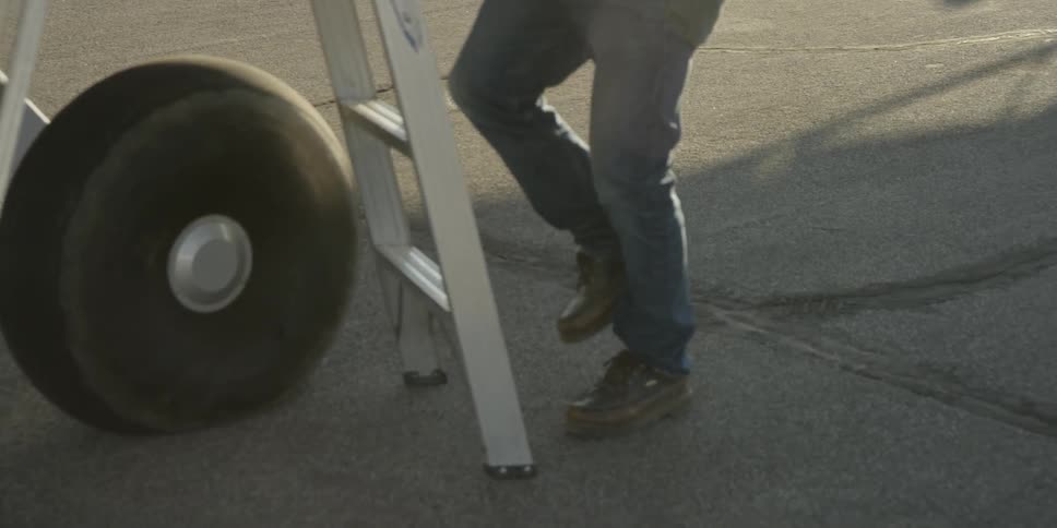 A man walks down a ladder from a plane