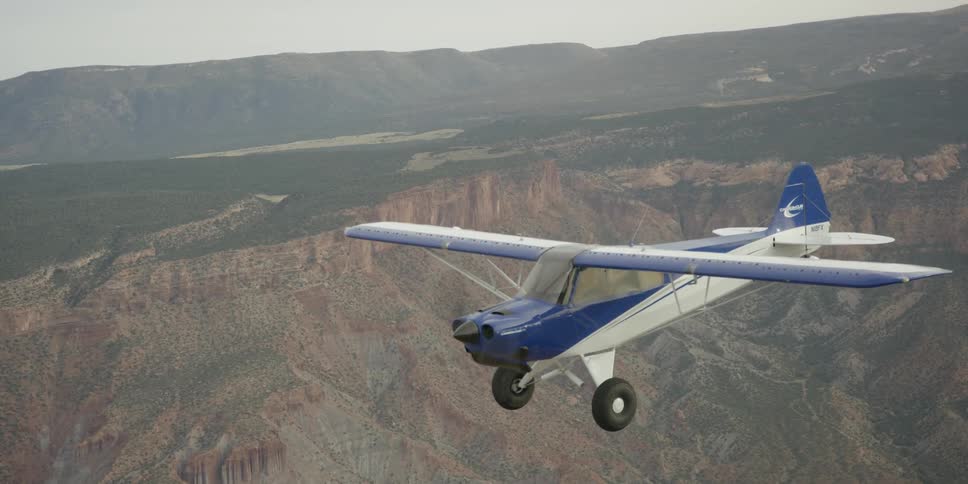 A plane is flying high over a canyon