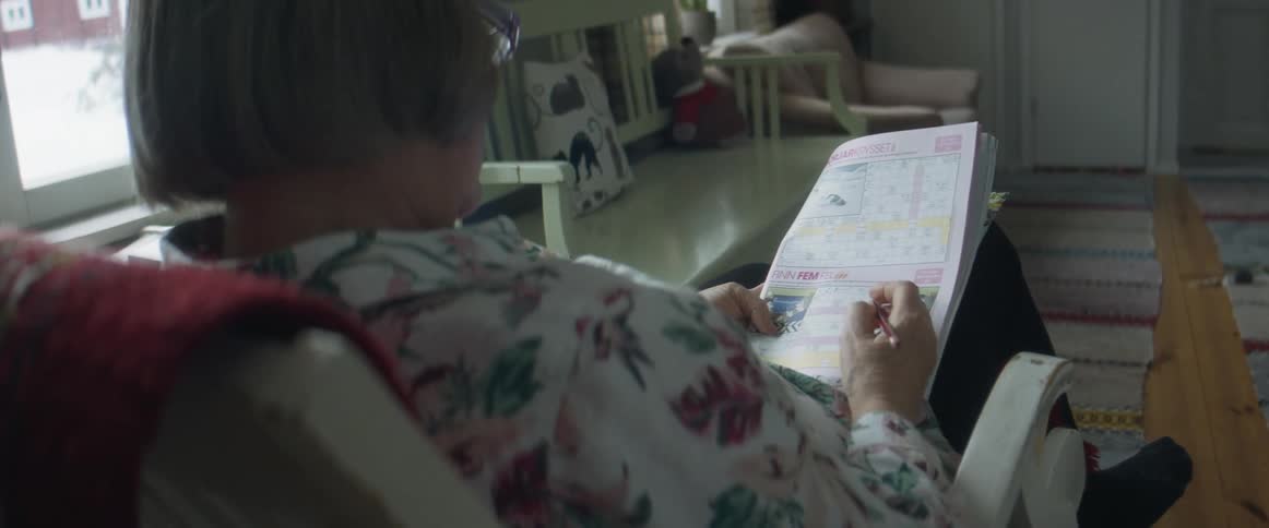 Woman solving crosswords sitting in the living room at home