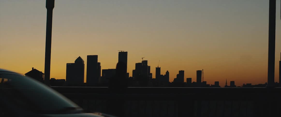 The silhouette of a city skyline is illuminated by the sun as it sits below the horizon