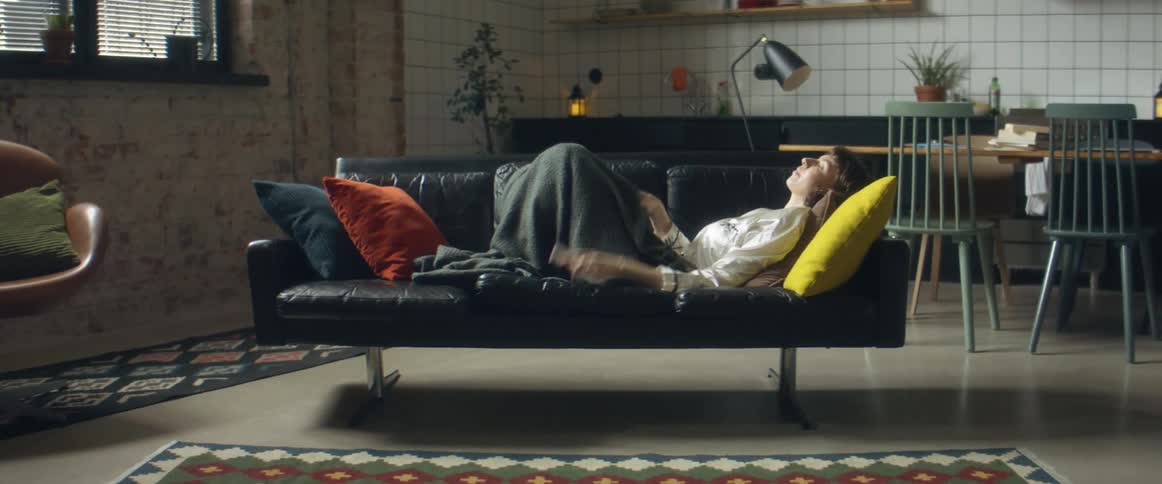 A woman relaxing and laying on a couch