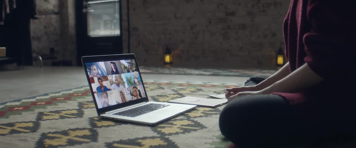 A woman talking to a group of people on a laptop