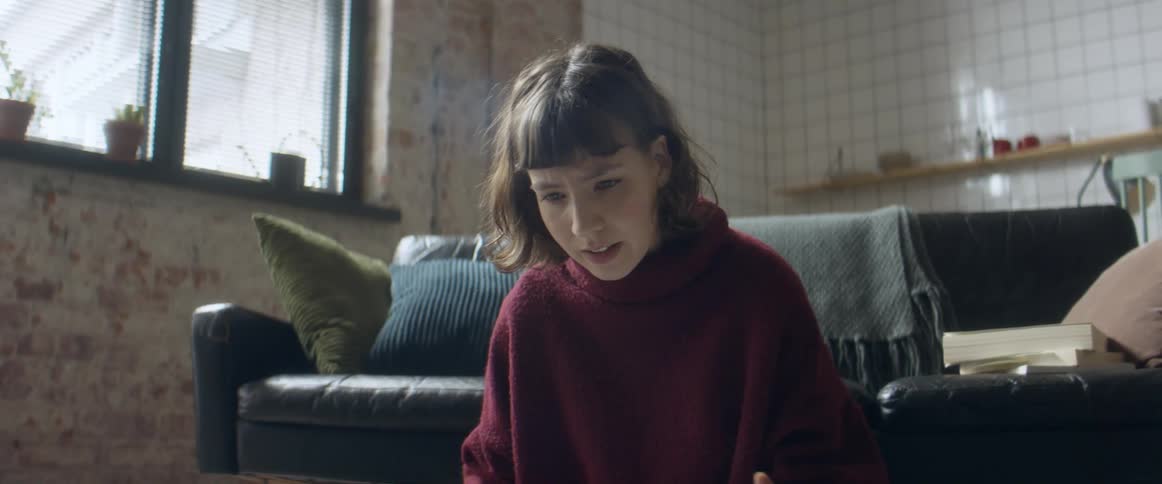 Woman sitting on the floor of the living room talking to friends on a video conference