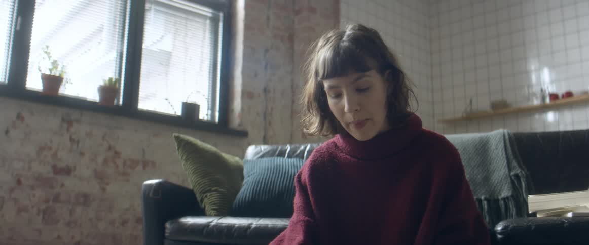 A woman studies on the floor of her living room while having a conversation