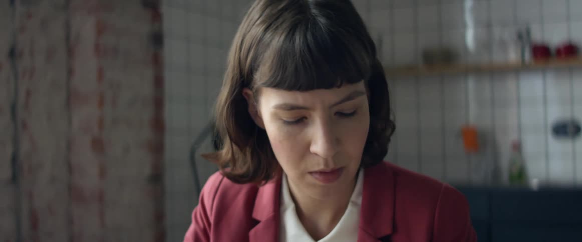 A woman in a room with a wall in the background