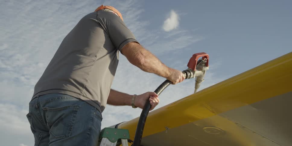 A man is fueling a plane