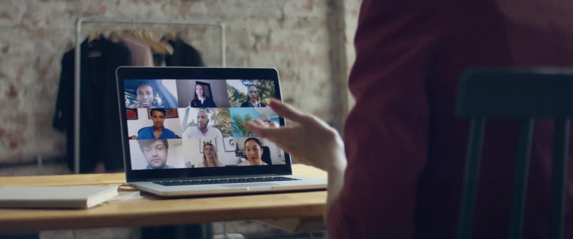 A group of workers talking on a laptop