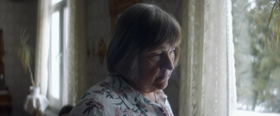 A woman looking sadly out a window