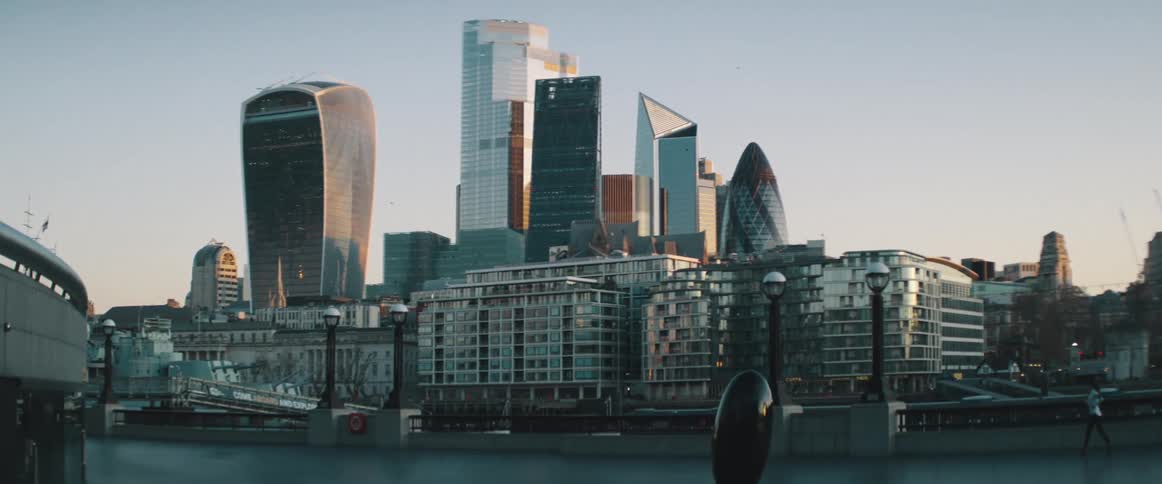 A woman jogging with buildings skyscrapers the sky and clouds in the background