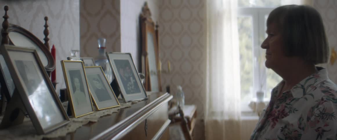 A woman putting a picture on a mantle