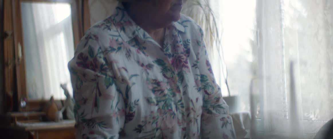 Woman sitting on the living room stands up to look out the window