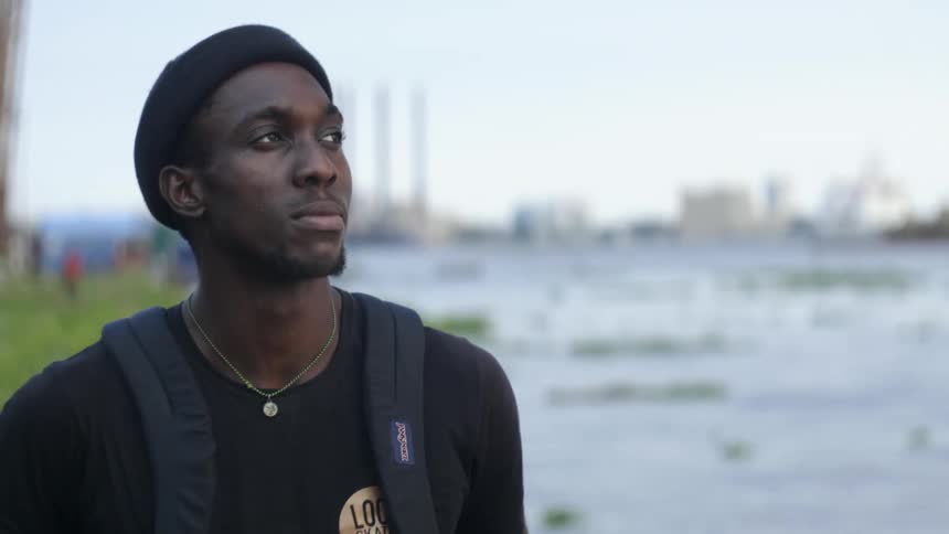 A man stands on the shore and looks off in to the distance