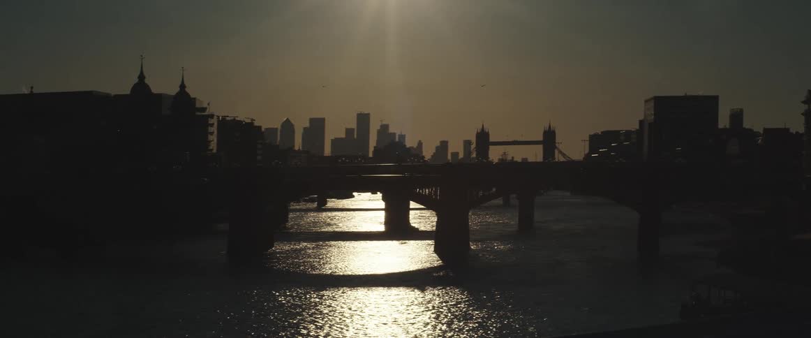 A river with bridges with the city skyline the sky and clouds in the background