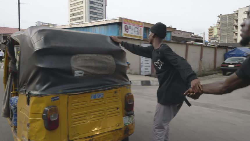 Two young men on inline skates hitching a ride on a rickshaw