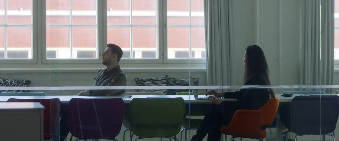 Two coworkers talking in a conference room