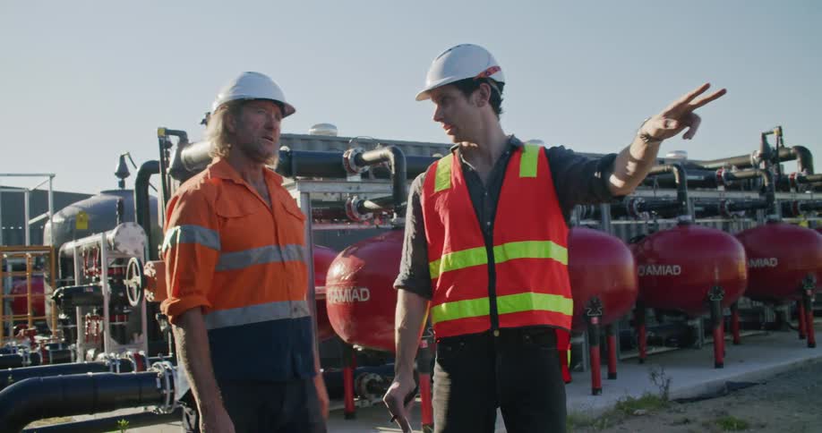 Two coworkers talking to each other at a construction site