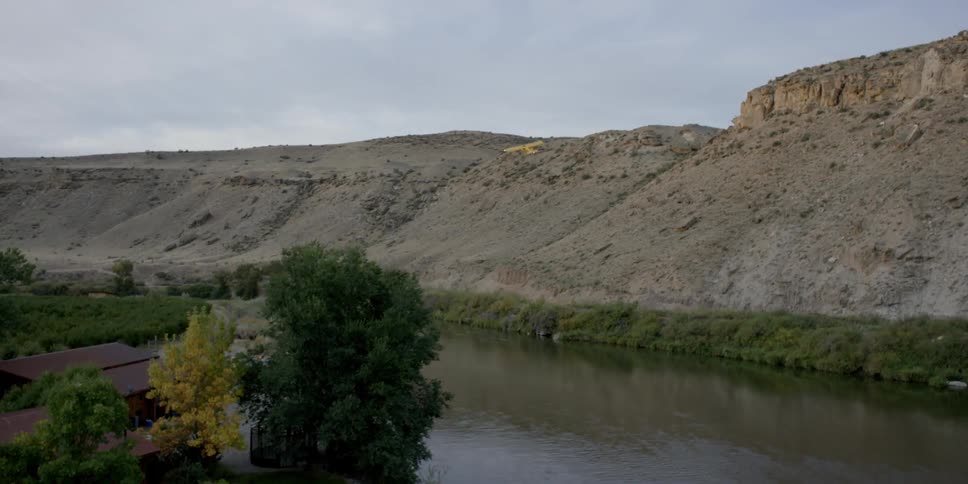 A small airplane soars over a river