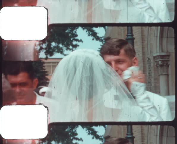 A wedding couple outside a church celebrating with a small crowd