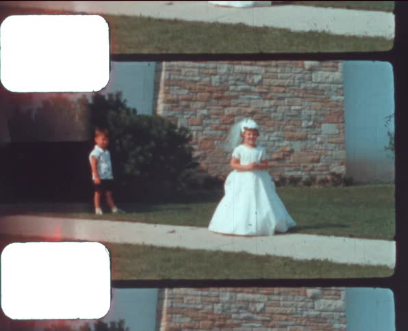 Three white children outside playing a wedding scene in the front yard