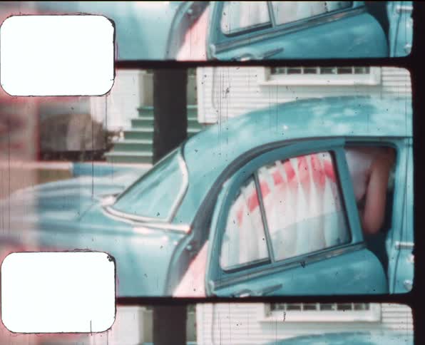 A vintage film of a young woman climbing in to the back of a car in a neighborhood