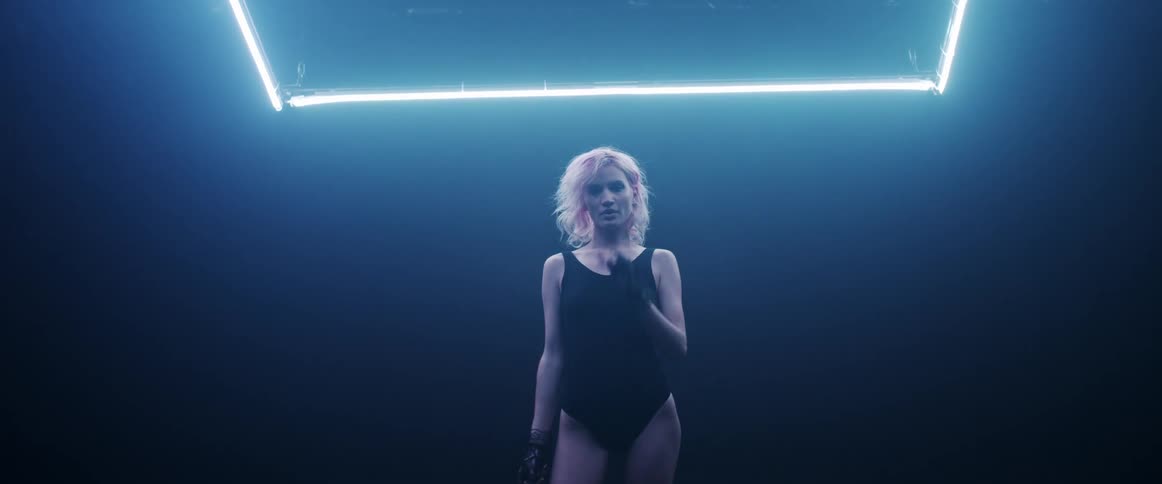 A woman with gloves and stockings standing in a room with lights in the background