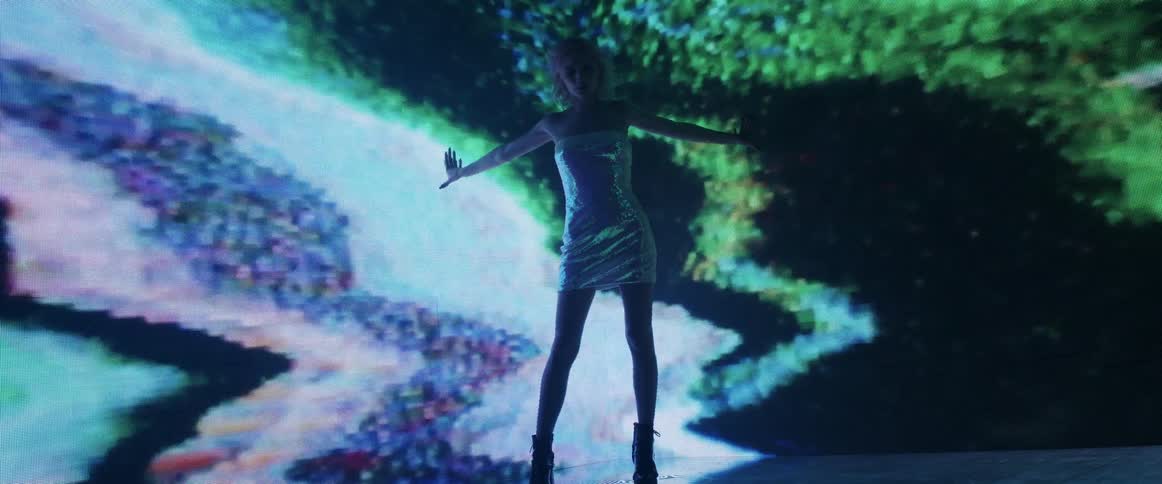 Woman wearing a silver dress standing in front of a digital display