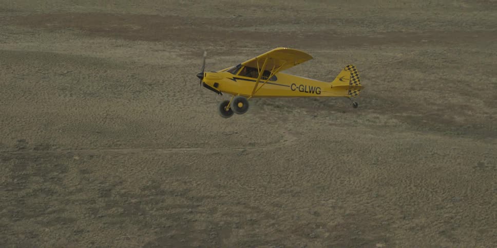 A yellow plane is flying high