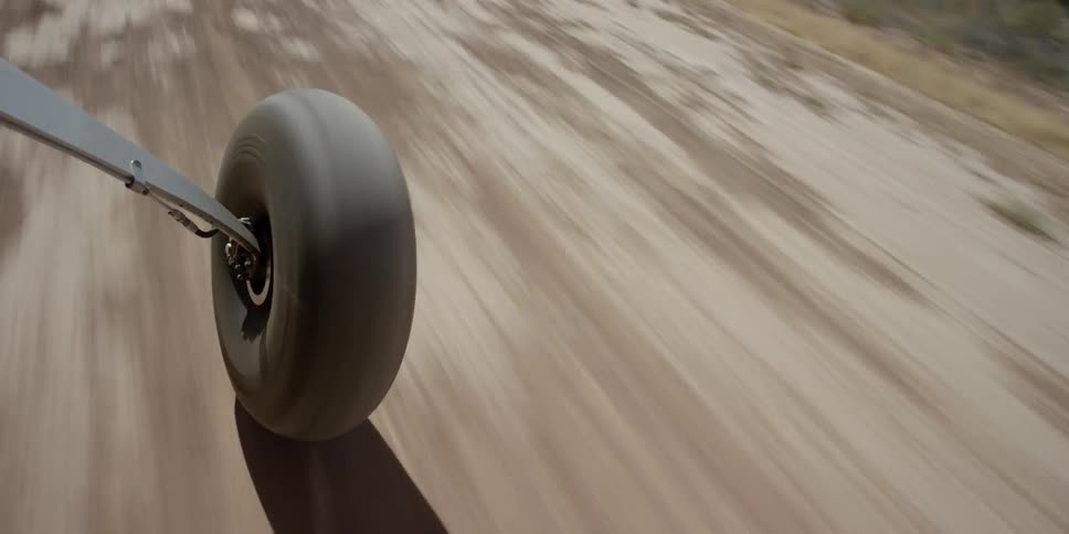 A wheel rolls quickly along a dirt road