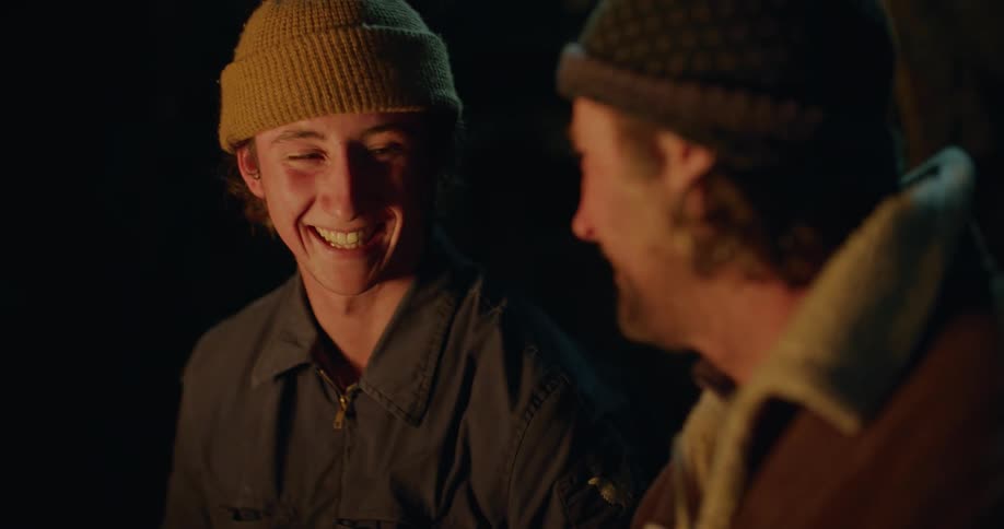 Father and son sitting in front of a campfire
