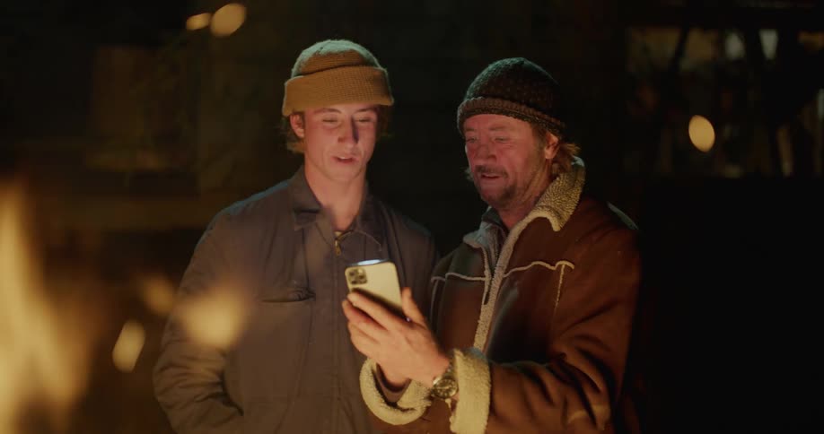 Father and son outside at a campfire at night