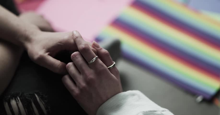 Two people intimately holding hands