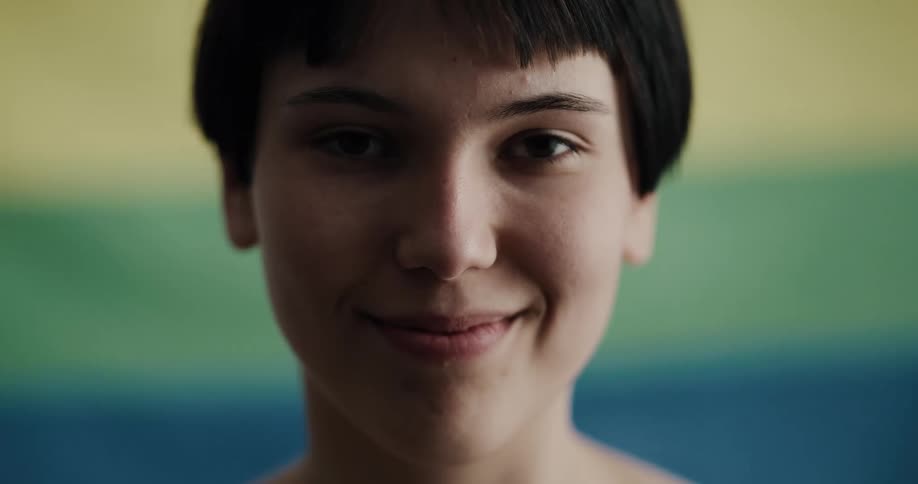 A teenage girl looks up and smiles for a portrait