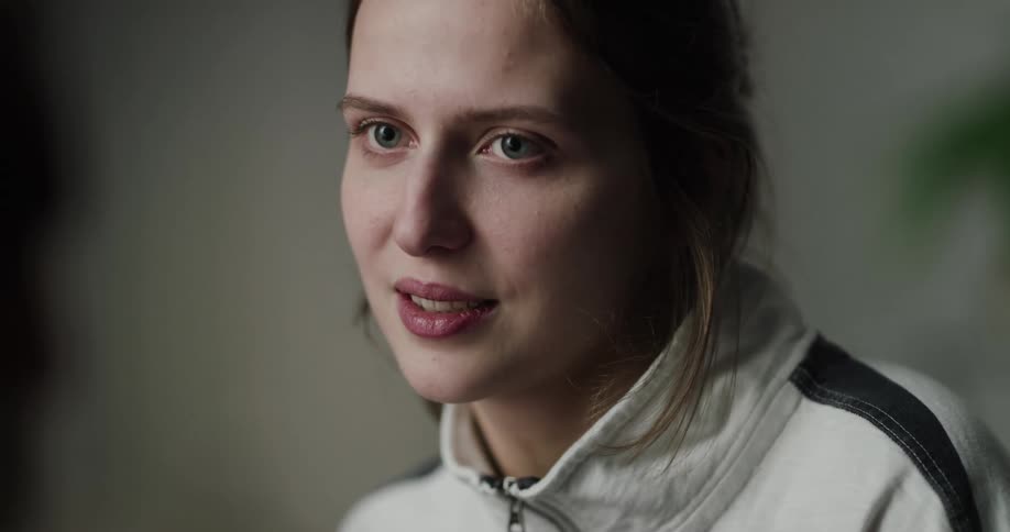 A woman is sitting in a room and smiling