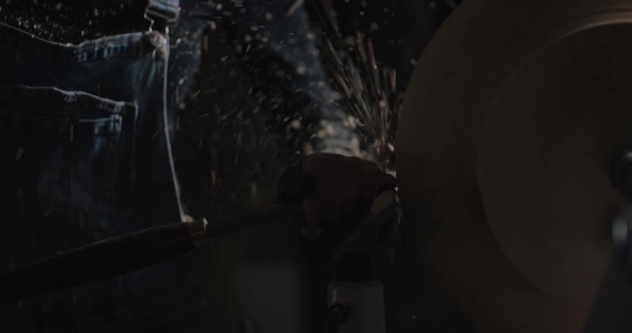 A woman working on wood on a lathe
