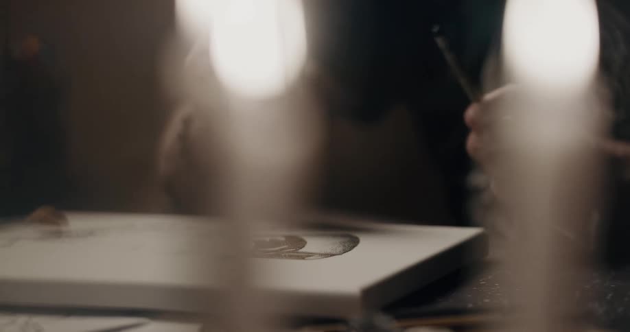 An artist uses a pen to shade in a picture