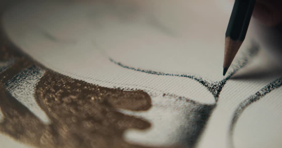 Close up of a pencil as it draws on material