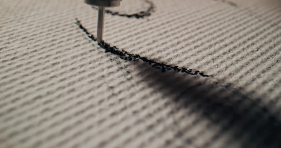A machine is stitching into fabric