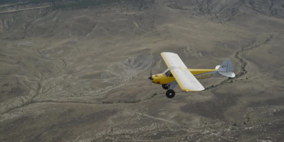 A yellow plane is flying